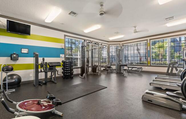 a workout room with weights and other exercise equipment at the enclave at woodbridge apartments in sugar