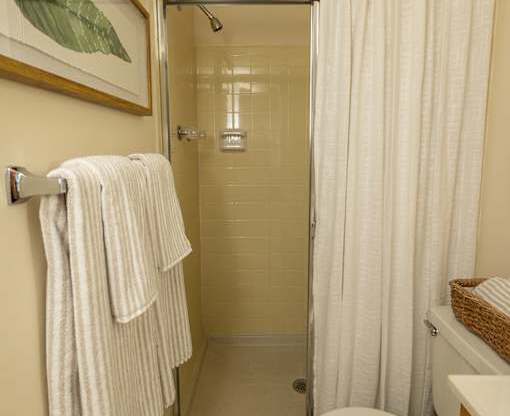 A white towel is hanging on a towel rack in a bathroom.
