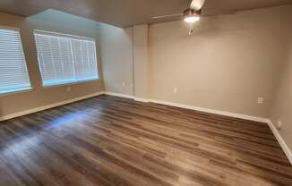 A room with wooden flooring and a window with blinds.