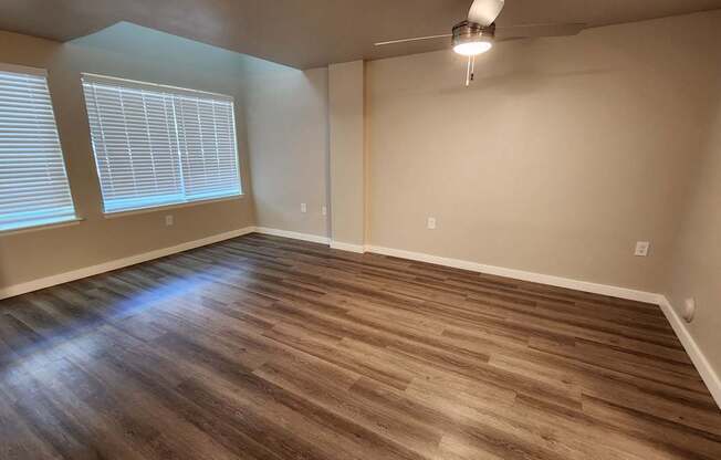 A room with wooden flooring and a window with blinds.