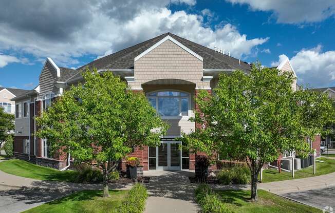 A modern house with a large front yard and trees.