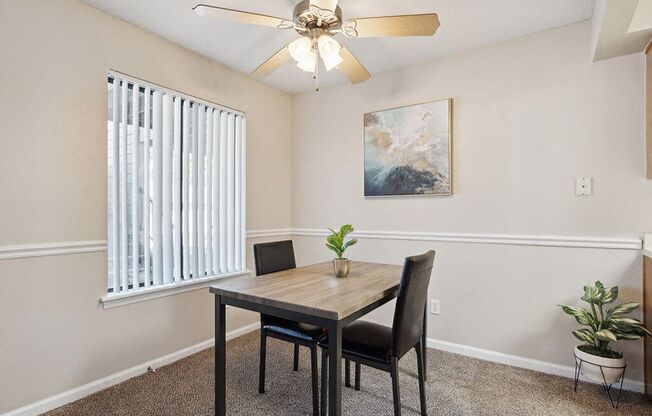 a dining room with a table and chairs and a ceiling fan