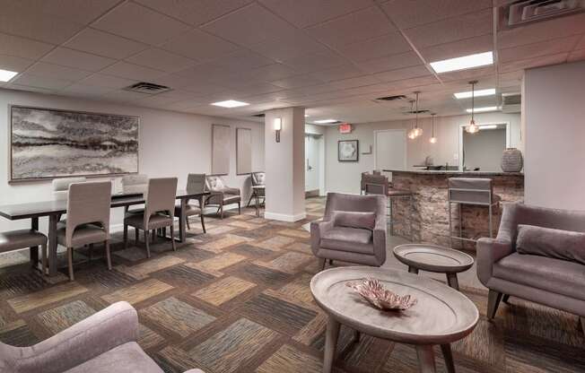 a lounge area with chairs and tables and a reception desk