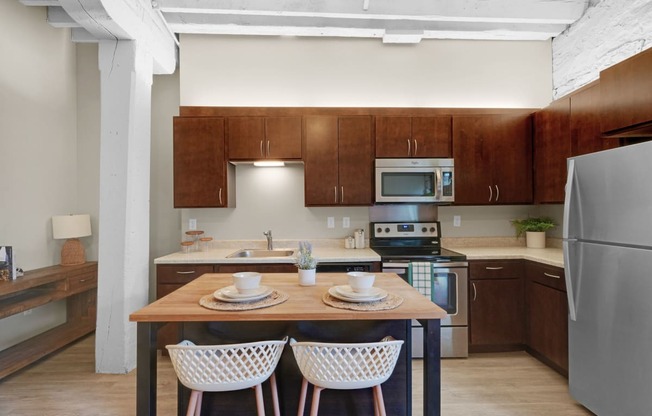 a kitchen with wooden cabinets and a wooden table