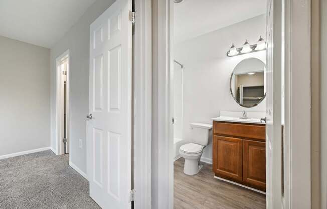 a bathroom with a toilet and a vanity with a mirror at ReNew Odenton