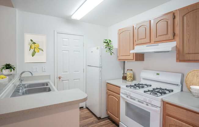 a kitchen with white appliances and wooden cabinets and a white refrigerator