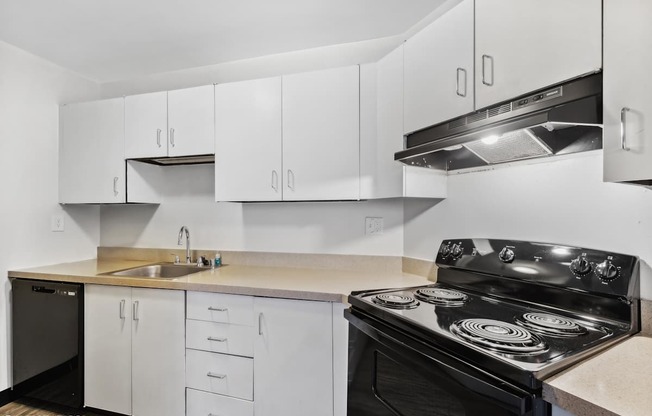 a kitchen with white cabinets and black appliances and a sink