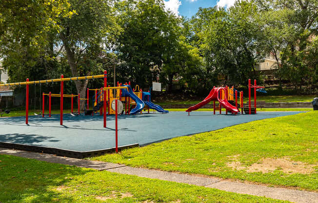 A playground with a blue slide and red and yellow play structures at Vermella Lyndhurst apartments, Lyndhurst, New Jersey