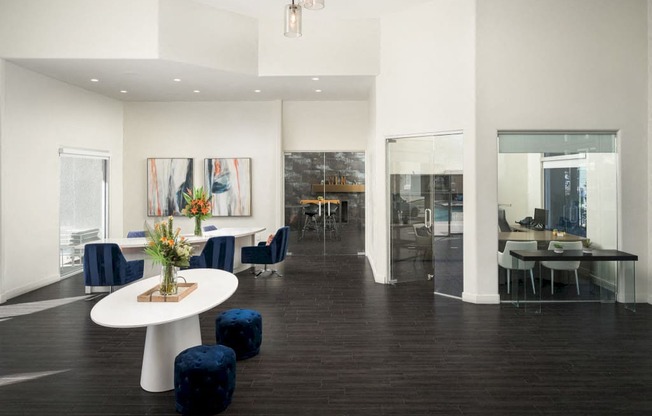 The Highland Leasing Office with dark floors, white table and navy chairs