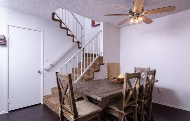 an image of a dining room with a table and chairs and a ceiling fan