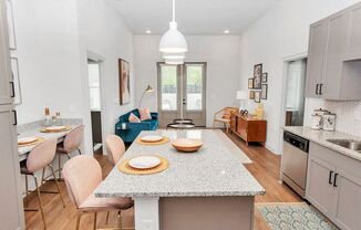 a kitchen with a large island with a granite countertop