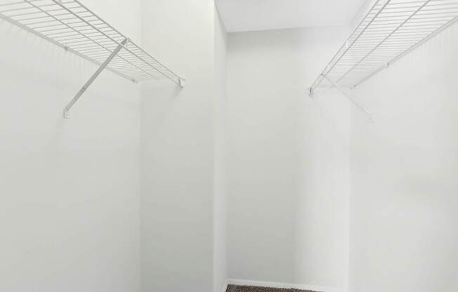 A white wall with a metal shelf on it.