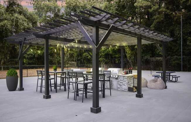 Greentree Apartments in Savannah, GA photo of a patio with tables and chairs and a pergola