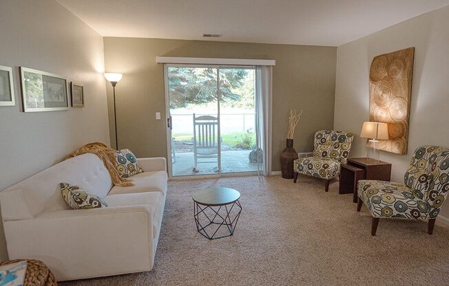 a living room with a couch and chairs and a sliding glass door