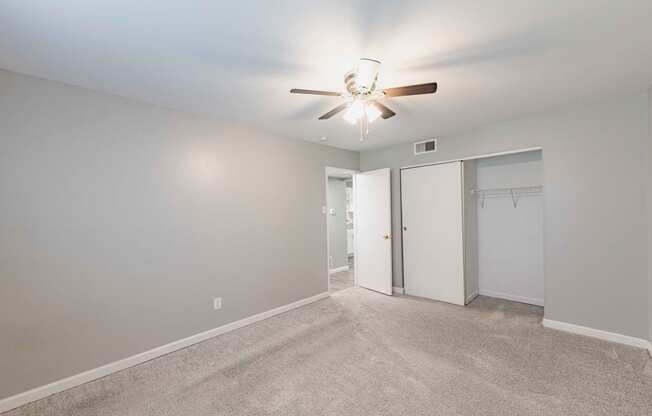 a bedroom with a ceiling fan and closet