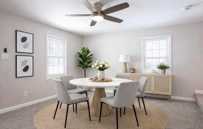 A dining room with a round table and chairs.