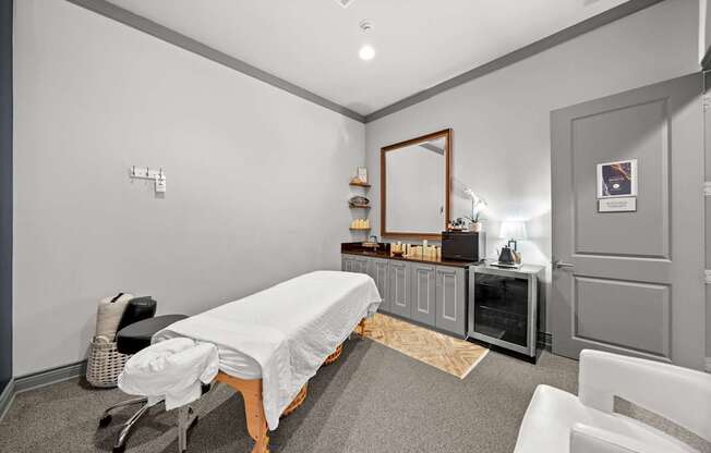 A room with a massage table and a mirror on the wall.