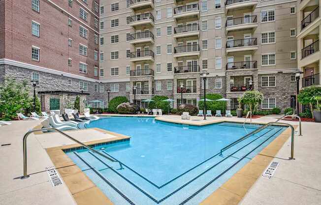 A large swimming pool in front of apartment buildings.