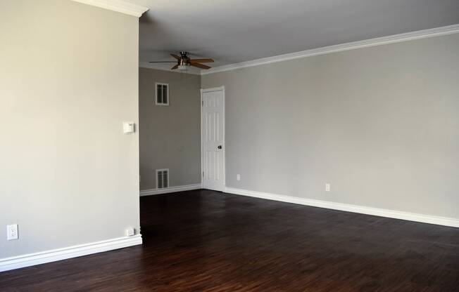 View from living area into dining area with wood look flooring and ceiling fan