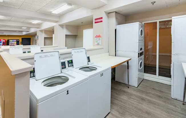 an empty utility room with washing machines and refrigeratorsat Royal Worcester apartments in Worcester MA