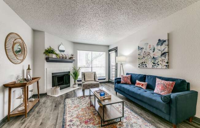 the living room of an apartment with a blue couch and a fireplace