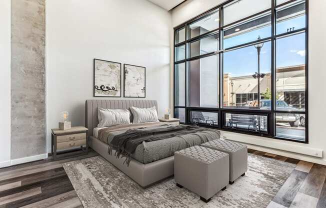 a bedroom with a bed and a large window