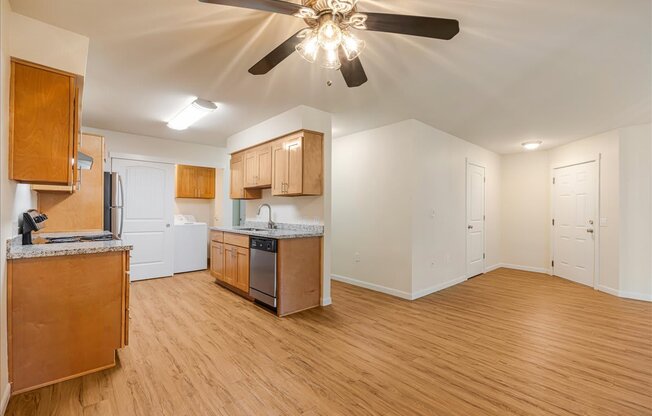Cascade Woods living area with kitchen and ceiling fan in view