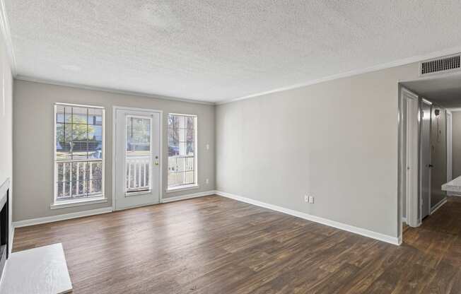A room with a sliding glass door and a white rug on the floor.