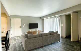 A grey couch with a wooden table in front of it.