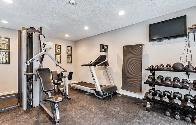 the gym has plenty of exercise equipment and a tv at The Broadwater at Salado Creek, San Antonio, Texas, 78216