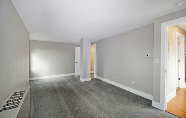 A room with a carpet floor and white walls.