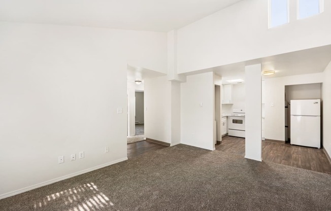 the living room and kitchen of an apartment with white walls and wood flooring at Park View Apartments, Wenatchee, WA