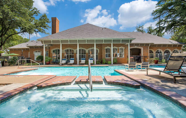 A pool in front of a house with a porch.