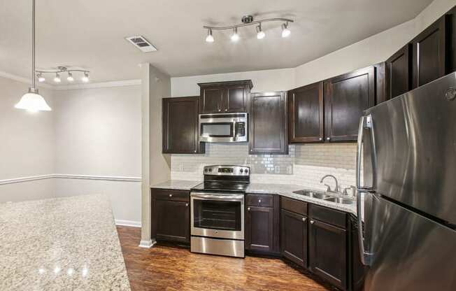 a kitchen with stainless steel appliances and dark wood cabinets