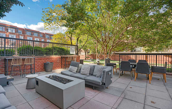 A patio with a fire pit and seating area.