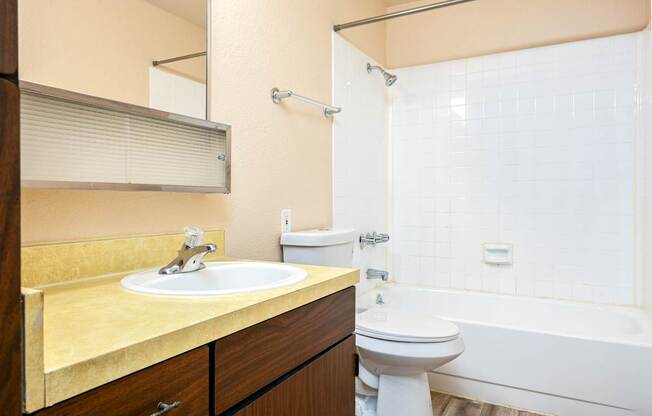 A bathroom with a sink, toilet, and bathtub.