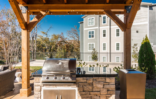 an outdoor kitchen with a grill and a wooden structure at Village at Westland Cove Apartments, Knoxville, TN, 37922