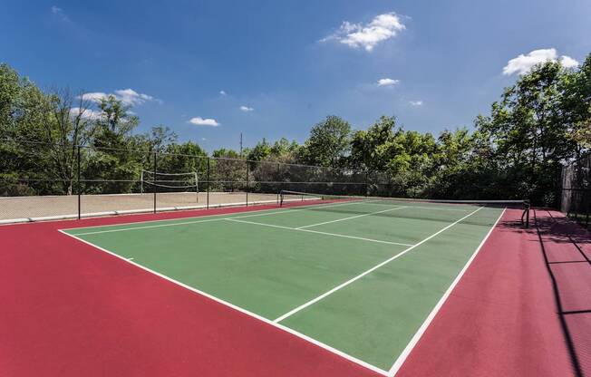 A tennis court with a red surface and white lines.