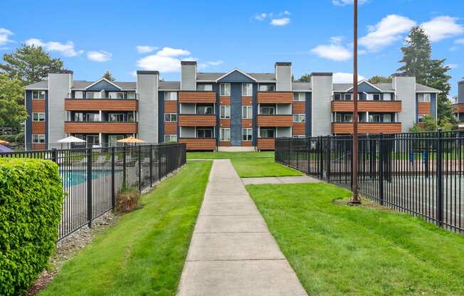 the view of a apartment building with a sidewalk and fence