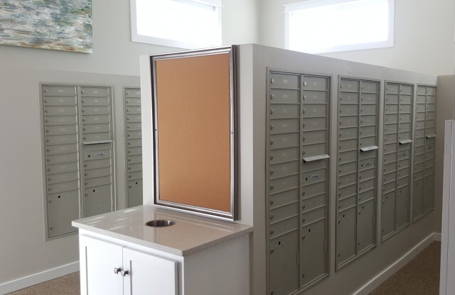Indoor mail room with community pin-board and trash area