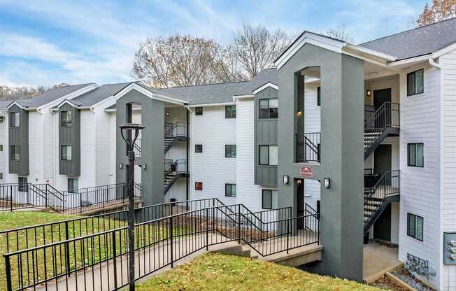 A row of white houses with black railings and steps leading to the doors.