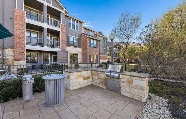 A patio area with a grill and a wall made of stone and brick.