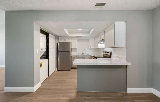 a renovated kitchen with white cabinets and stainless steel appliances