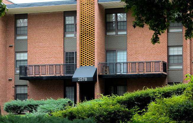 a large brick apartment building with a balcony and a 311 sign