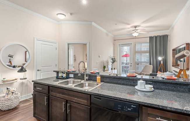 a kitchen with a sink and a counter top and a living room