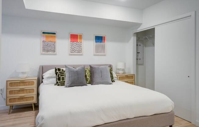 a bedroom with a bed and paintings on the wall