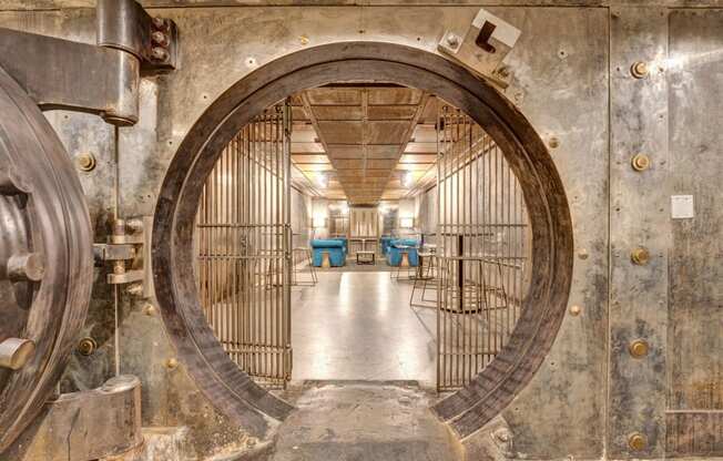 a large metal door in a room with tables and chairs
