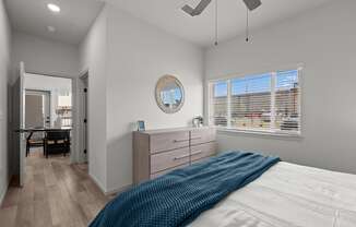 a bedroom with a bed and a dresser and a window