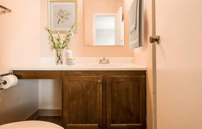 A bathroom with a wooden cabinet and a white sink.