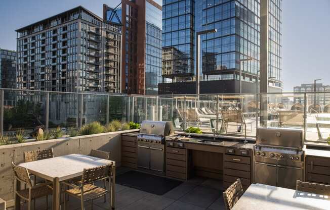 a roof deck with a grill and a table and chairs